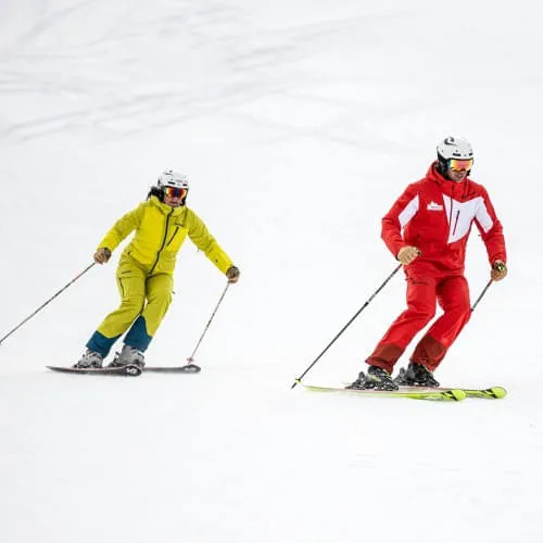 Skifahrer in verschiedenen Anzügen auf dem Schnee